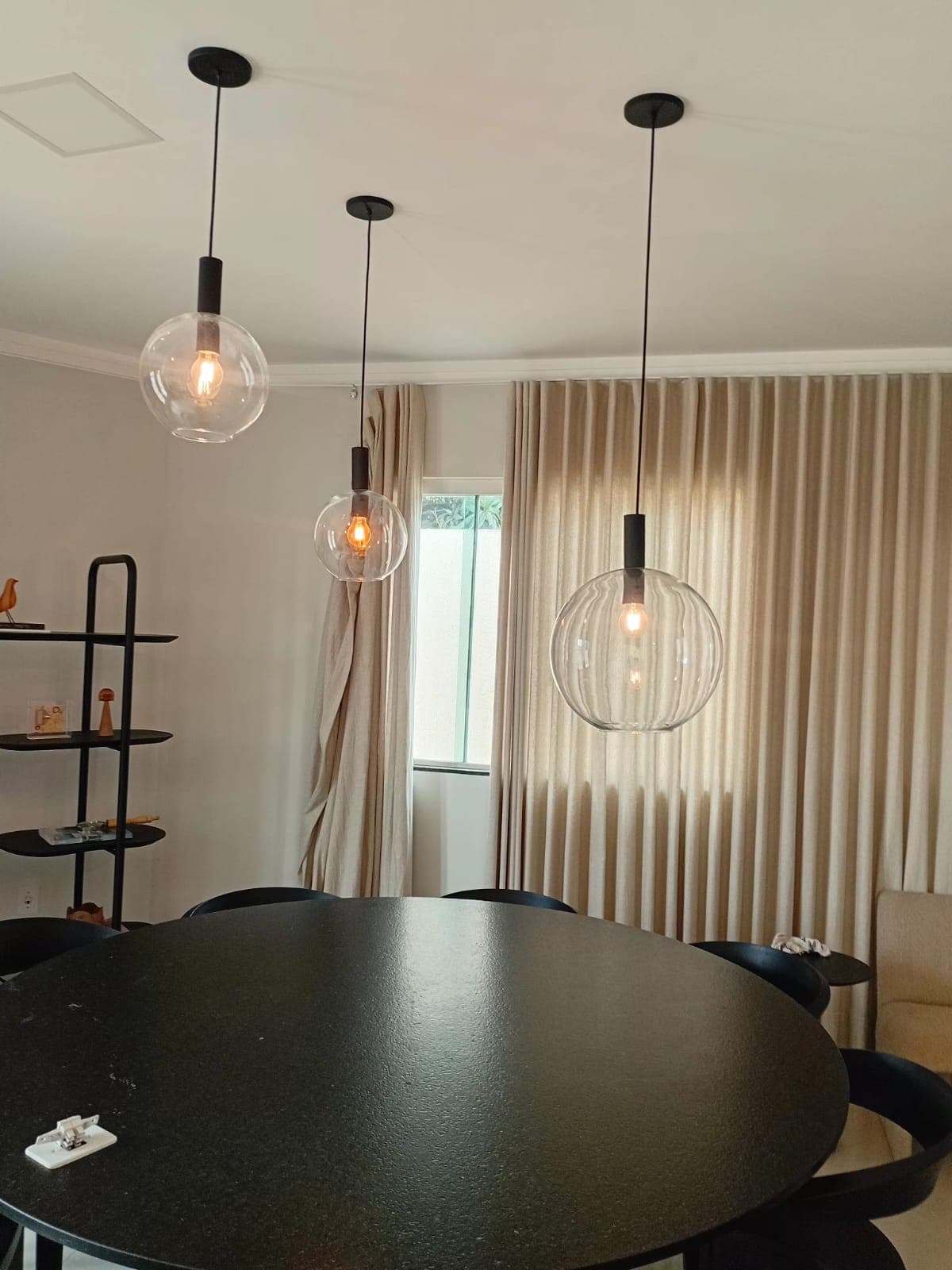 Pendentes de vidro instalados sobre mesa de jantar pela JMC